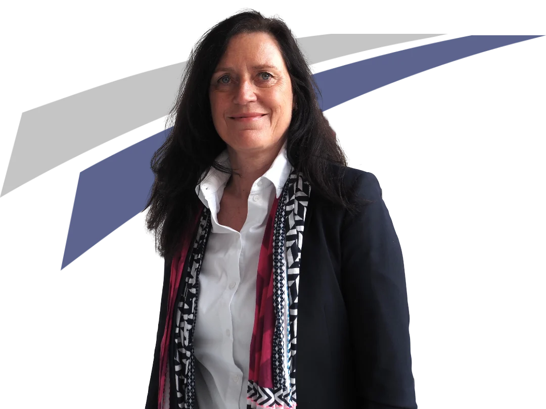 Frau mit langen, dunklen Haaren und einer oberen schwarzen Jacke, lächelt vor geometrischem, blau-grauem Hintergrund.