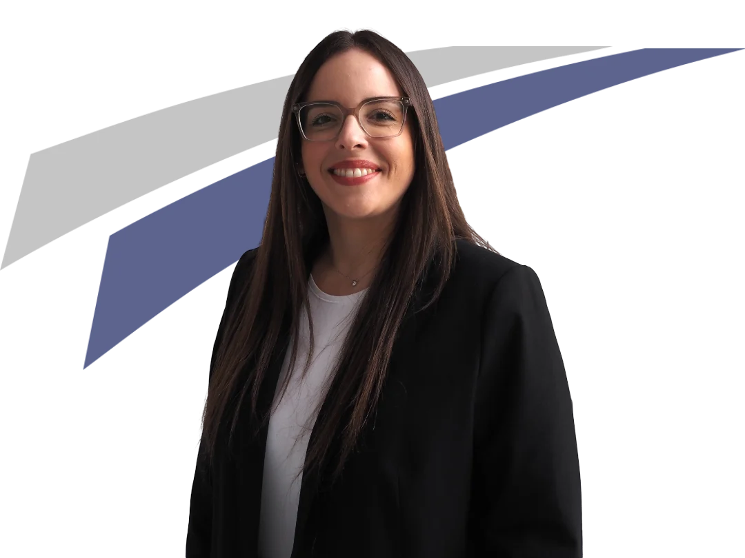 Ein Lächeln zeigt eine Frau mit langen, dunklen Haaren in einem schwarzen Blazer vor einem farbigen Hintergrund.