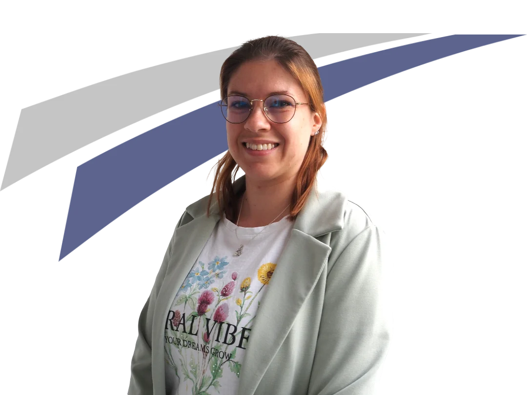 Junge Frau mit Brille und grünem Blazer, lächelnd vor einem grafischen Hintergrund. Sie trägt ein T-Shirt mit floralem Design.