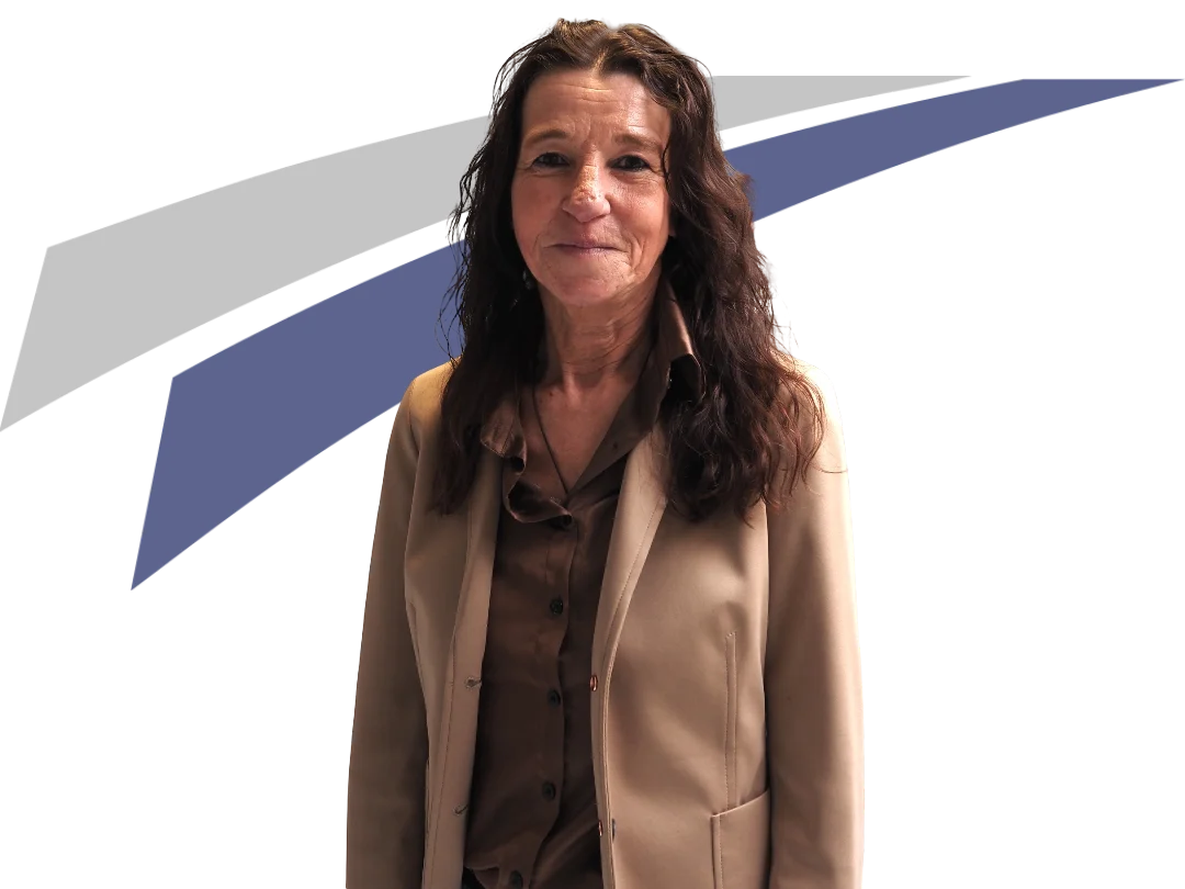 Frau mit langen, lockigen Haaren in beigem Blazer steht vor abstraktem, grafischem Hintergrund in Blau und Grau.