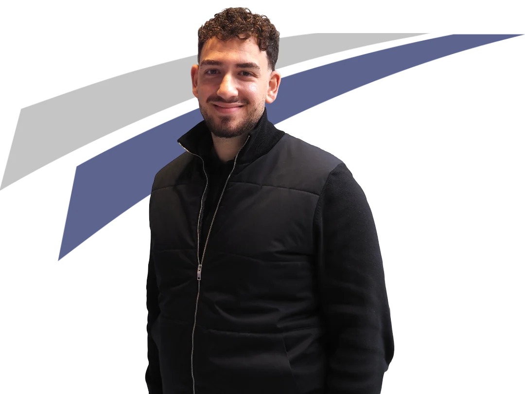 Junger Mann mit lockigem Haar in schwarzer Jacke, steht vor einem grafischen Hintergrund in Blau und Grau.