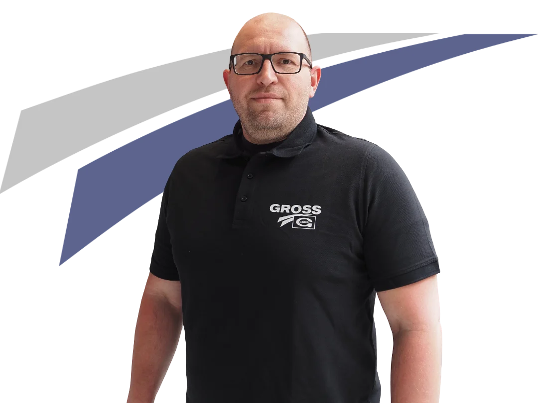 Mann in schwarzem Poloshirt mit Logo, steht vor einem grafischen Hintergrund in Blau und Grau.