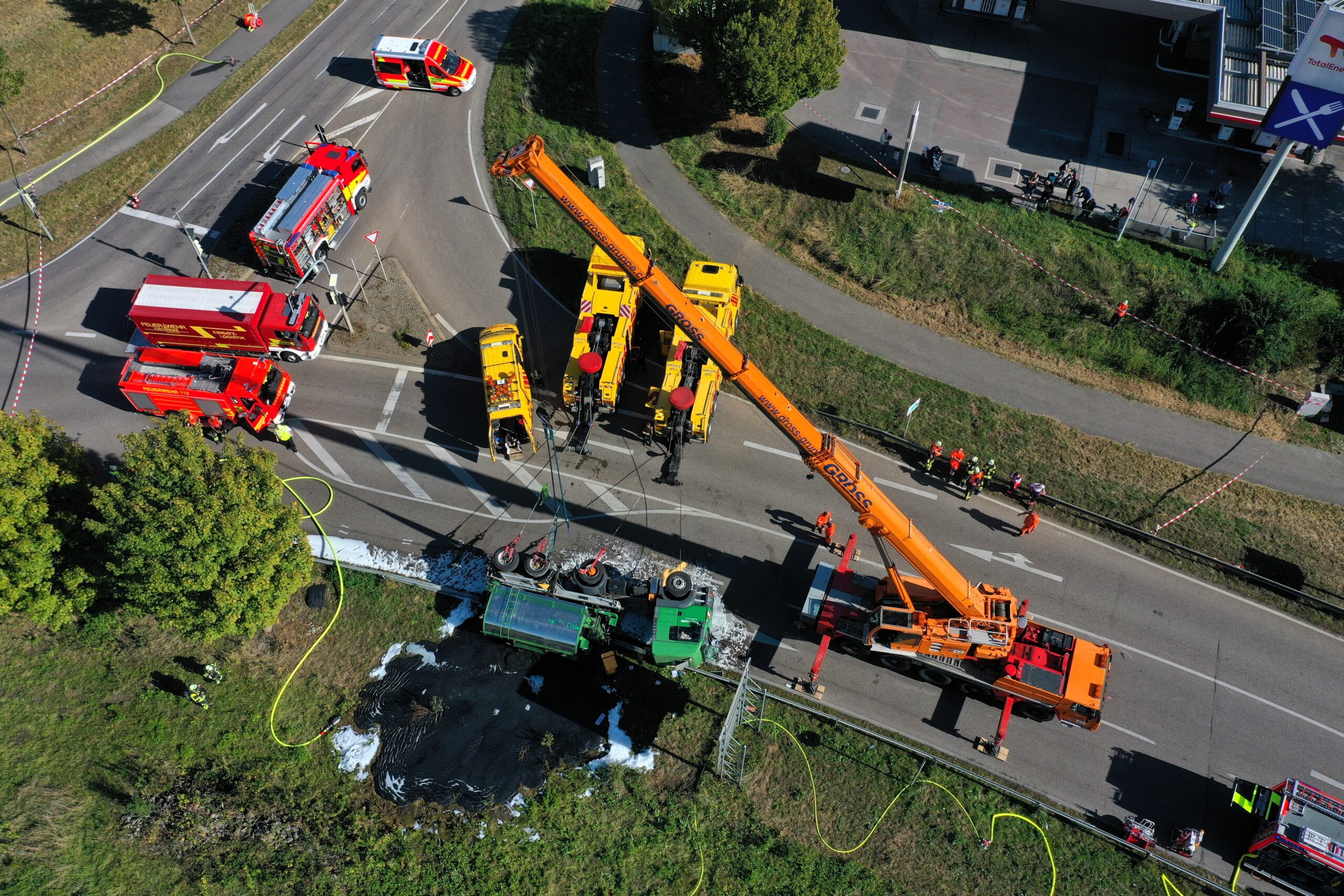 Unfall auf Landstraße: Umgekippter Lastwagen, Kran hebt ihn an, Feuerwehr und Einsatzfahrzeuge vor Ort.