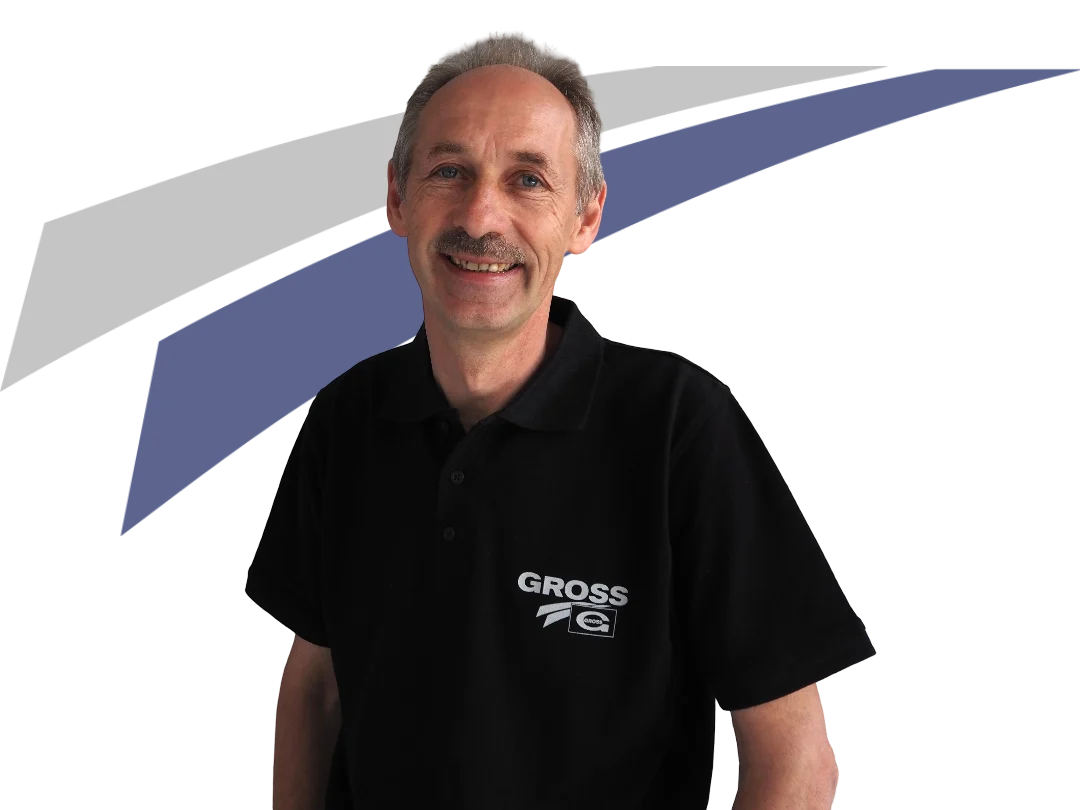 Lächelnder Mann in schwarzem Polo mit Logo auf weißem Hintergrund, grau-blauem Design hinter ihm.