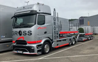 Silberner Mercedes-Lkw mit dem Schriftzug GROSS WEILHEIM, ausgestattet mit einem Anhänger für Transportzwecke.