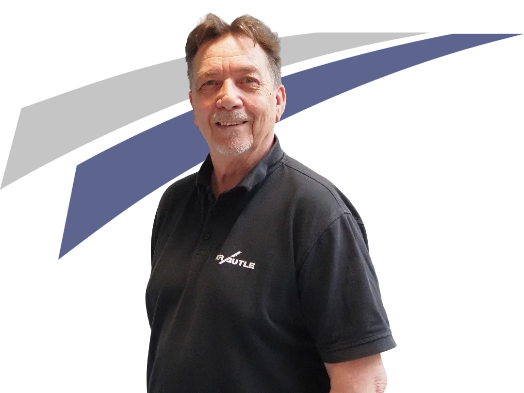 Mann in schwarzem Polohemd lächelt vor einem grafischen Hintergrund in Blau und Grau.